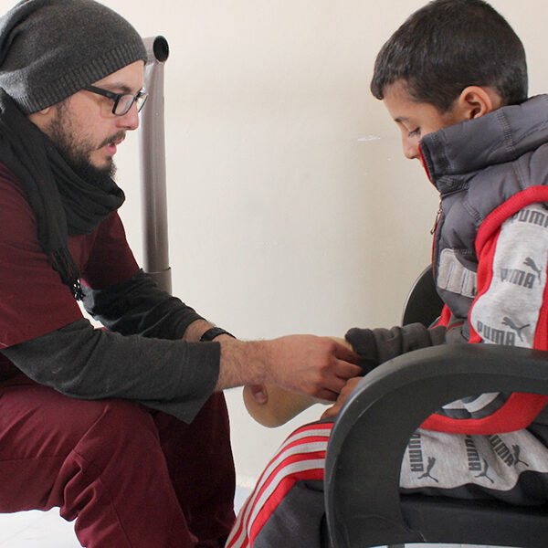 a student sitting with a child patient preparing for testing of a prosthesis