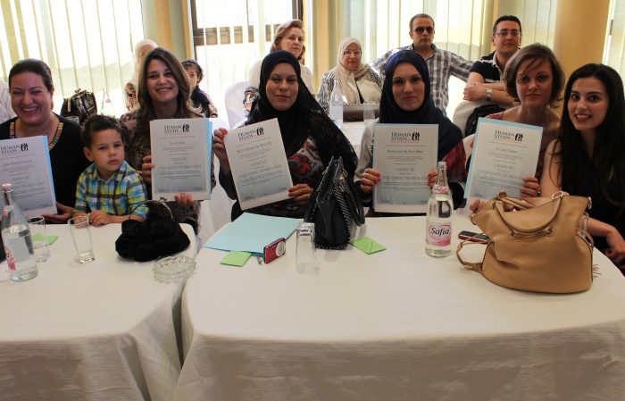 graduates sitting at a table with diplomas in their hands